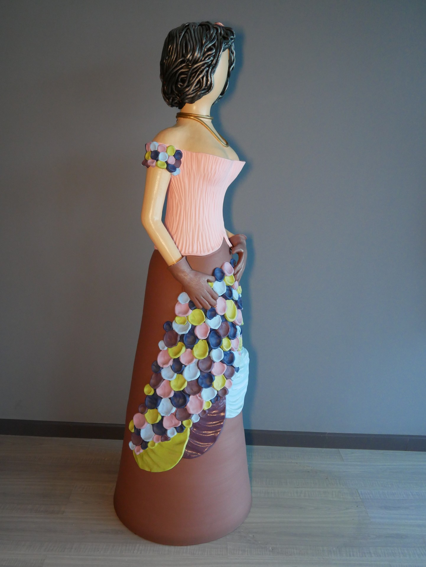 Estátua decorativa mulher com vestido longo castanho e padrão colorido em círculo