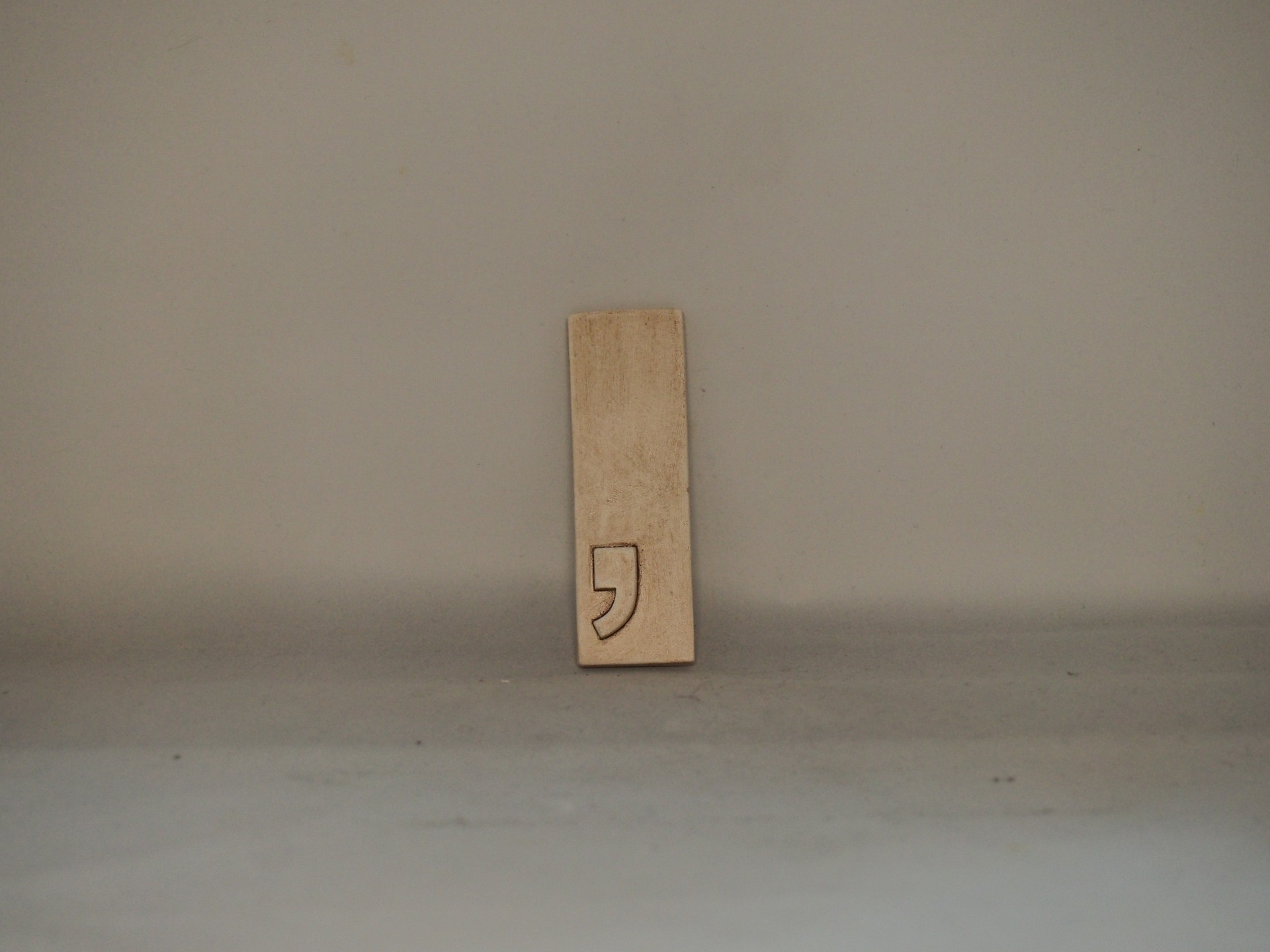 Carimbo de madeira com símbolo de vírgula