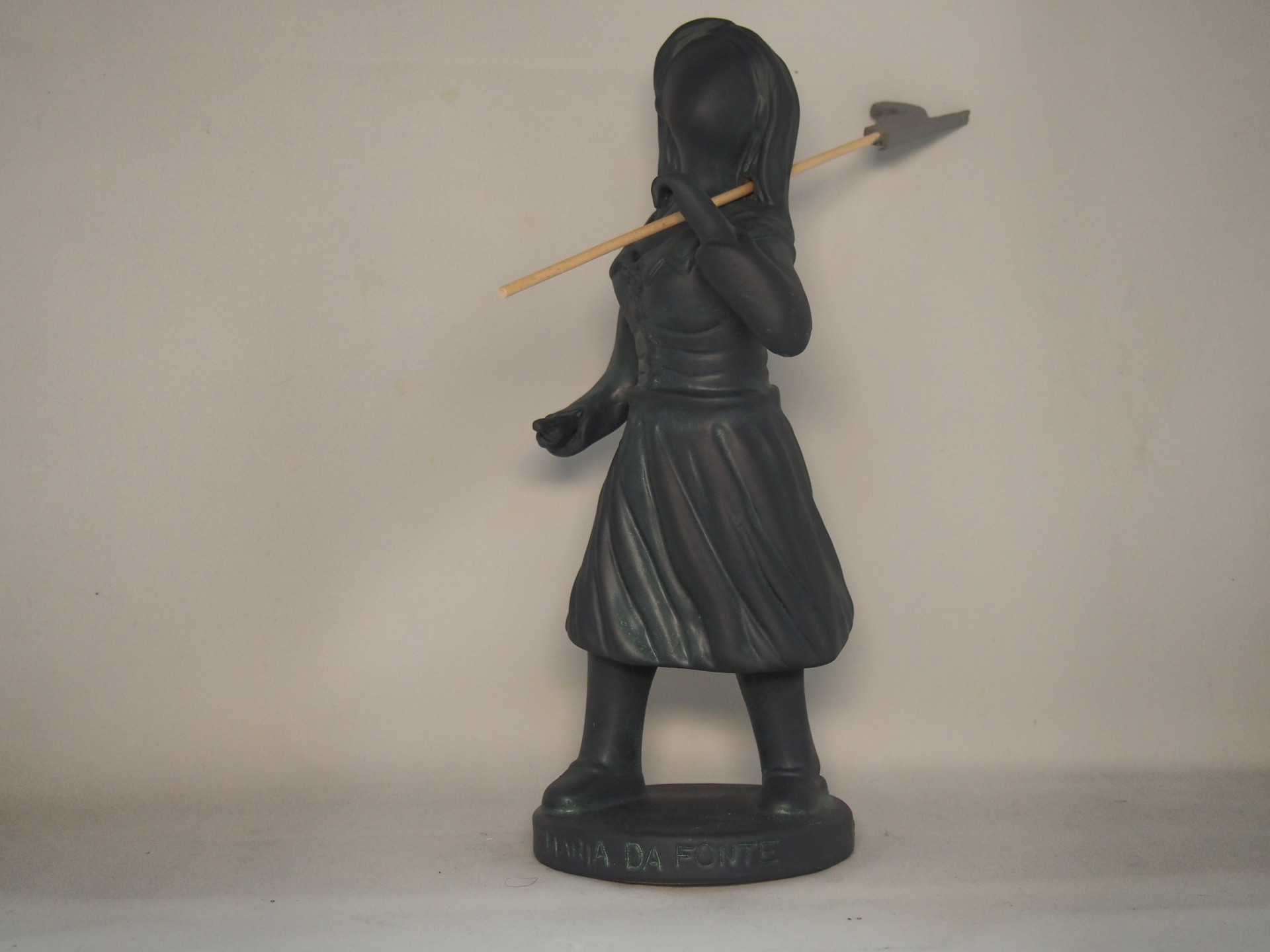 Estátua decorativa preta de figura feminina com flecha dourada