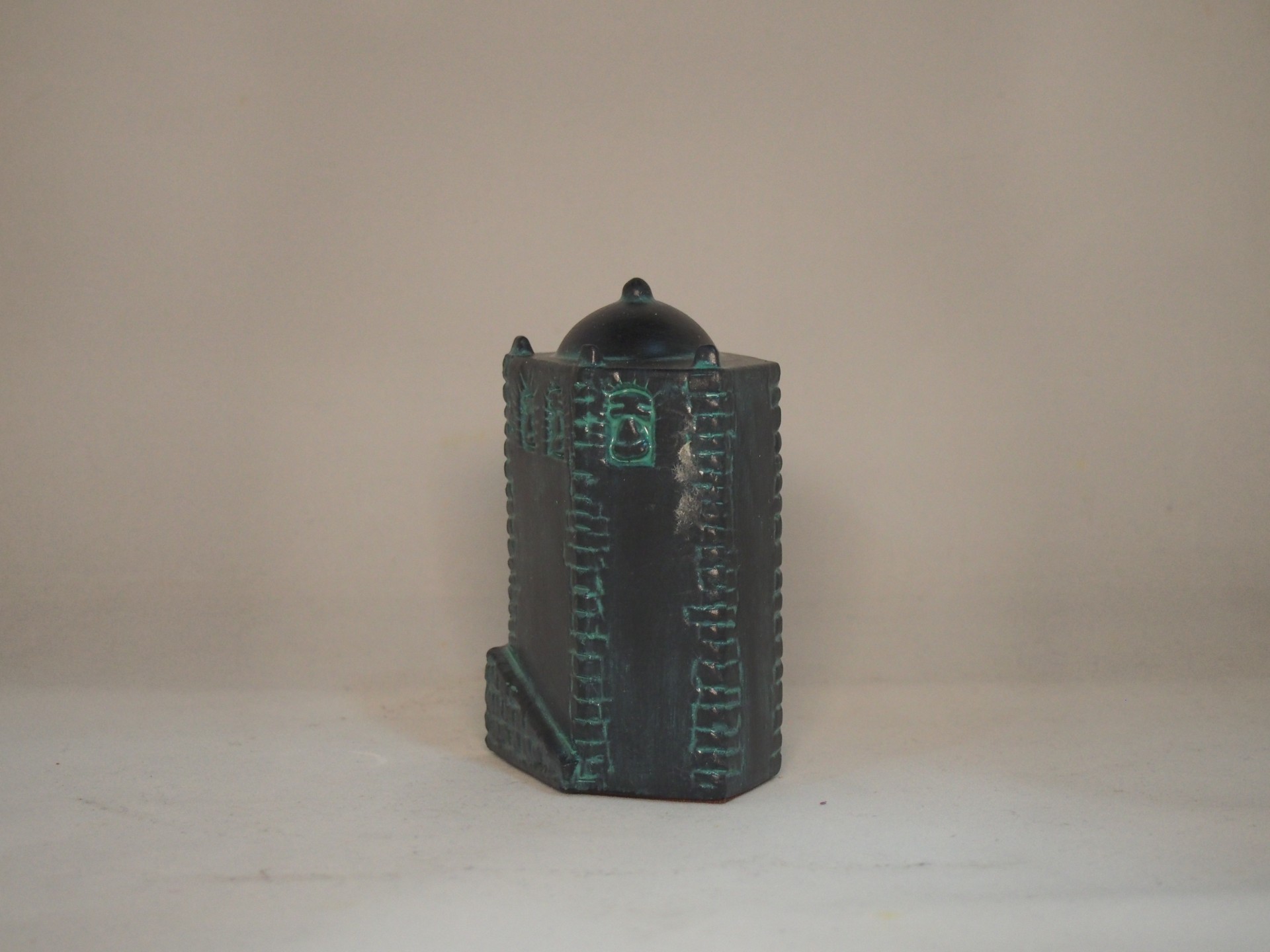 Figura decorativa em cerâmica verde escura com relevo