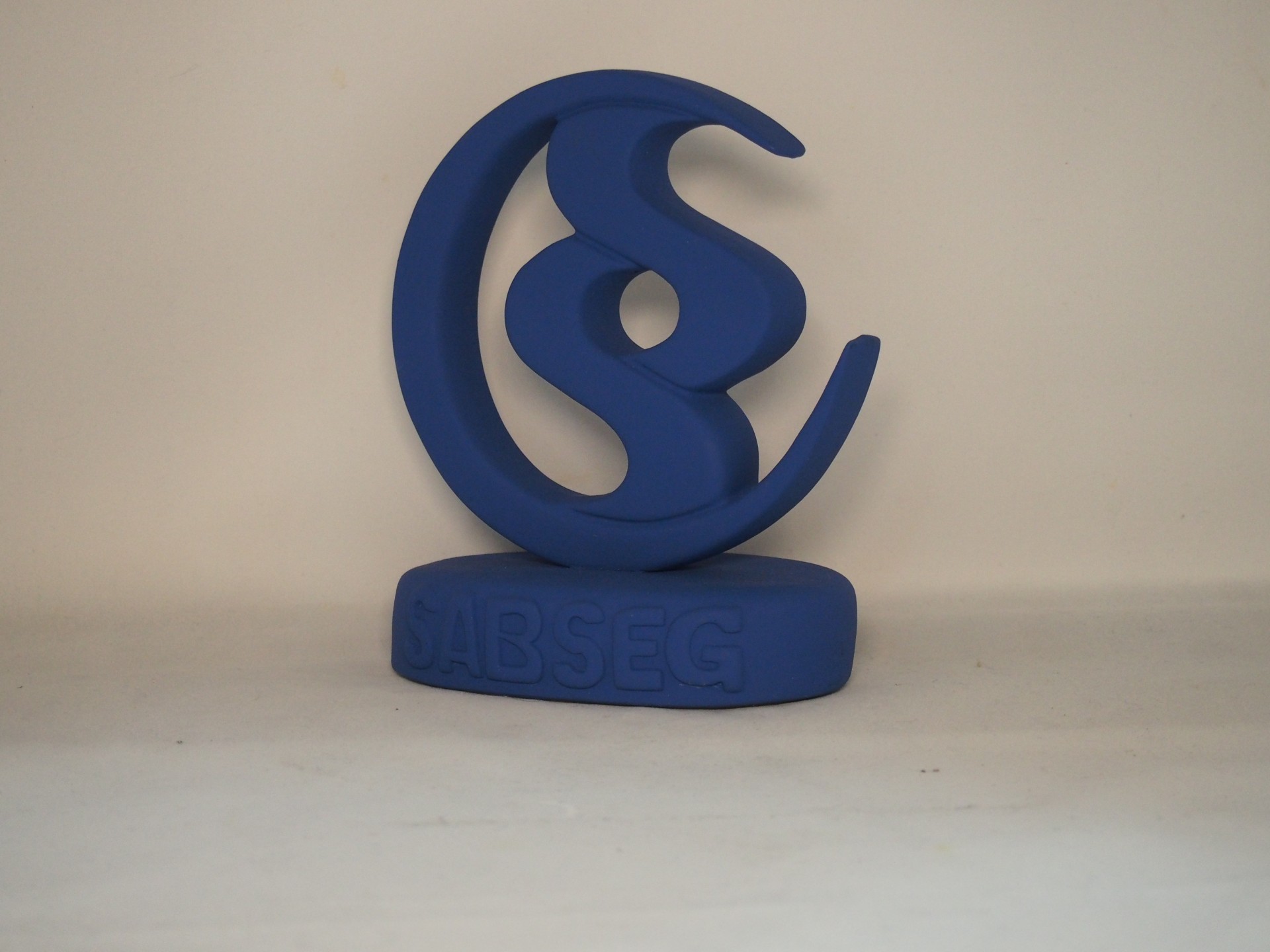 Escultura azul ABSEG sobre superfície branca