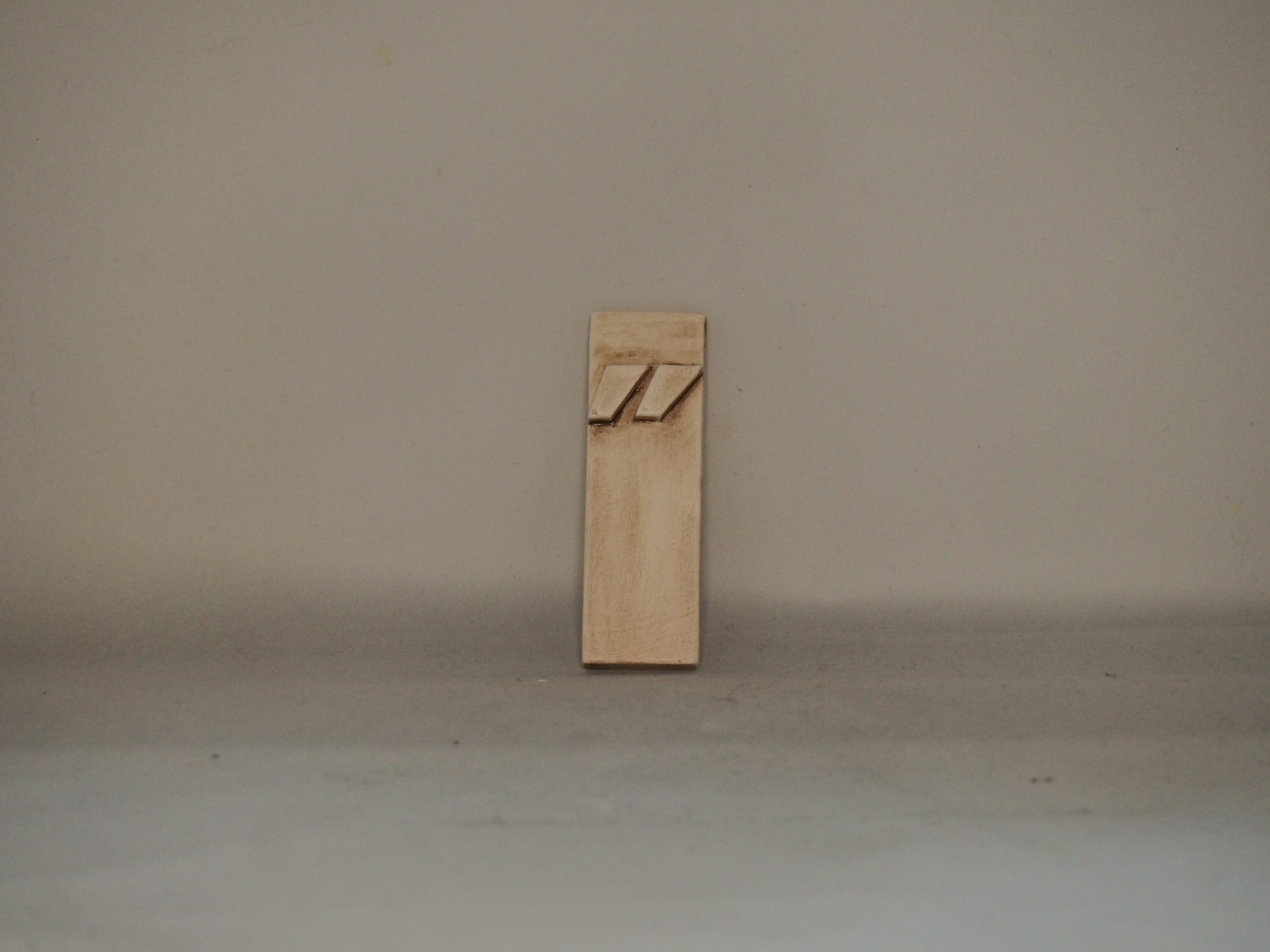 Suporte de parede em madeira clara com duas ranhuras inclinadas