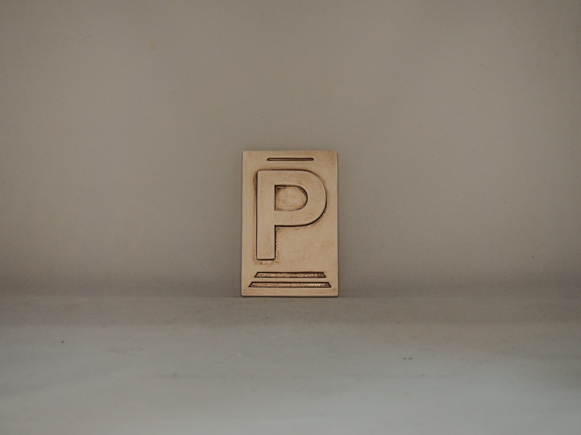 Placa em madeira com a letra P gravada