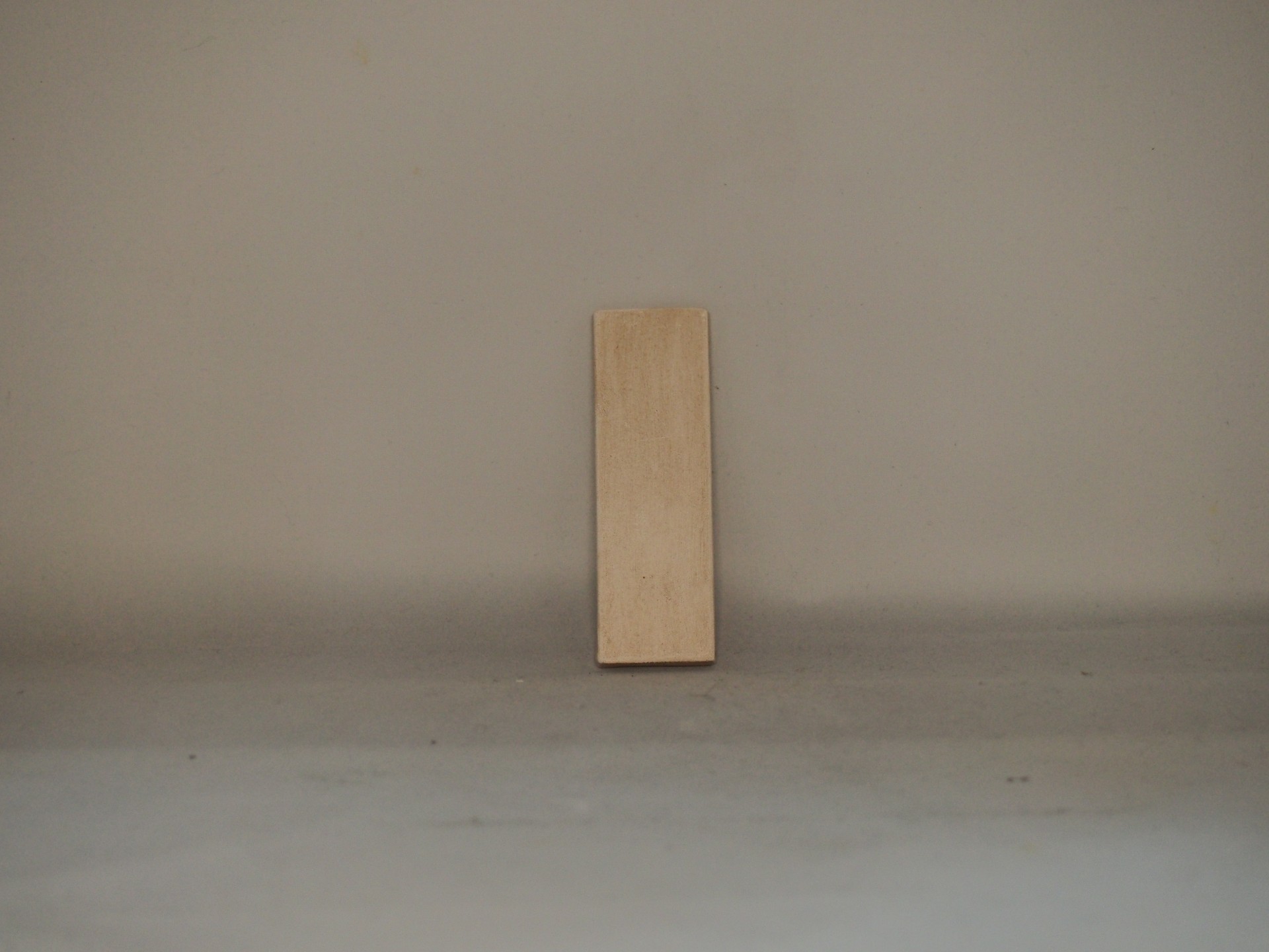 Tabela retangular de madeira clara contra parede cinzenta