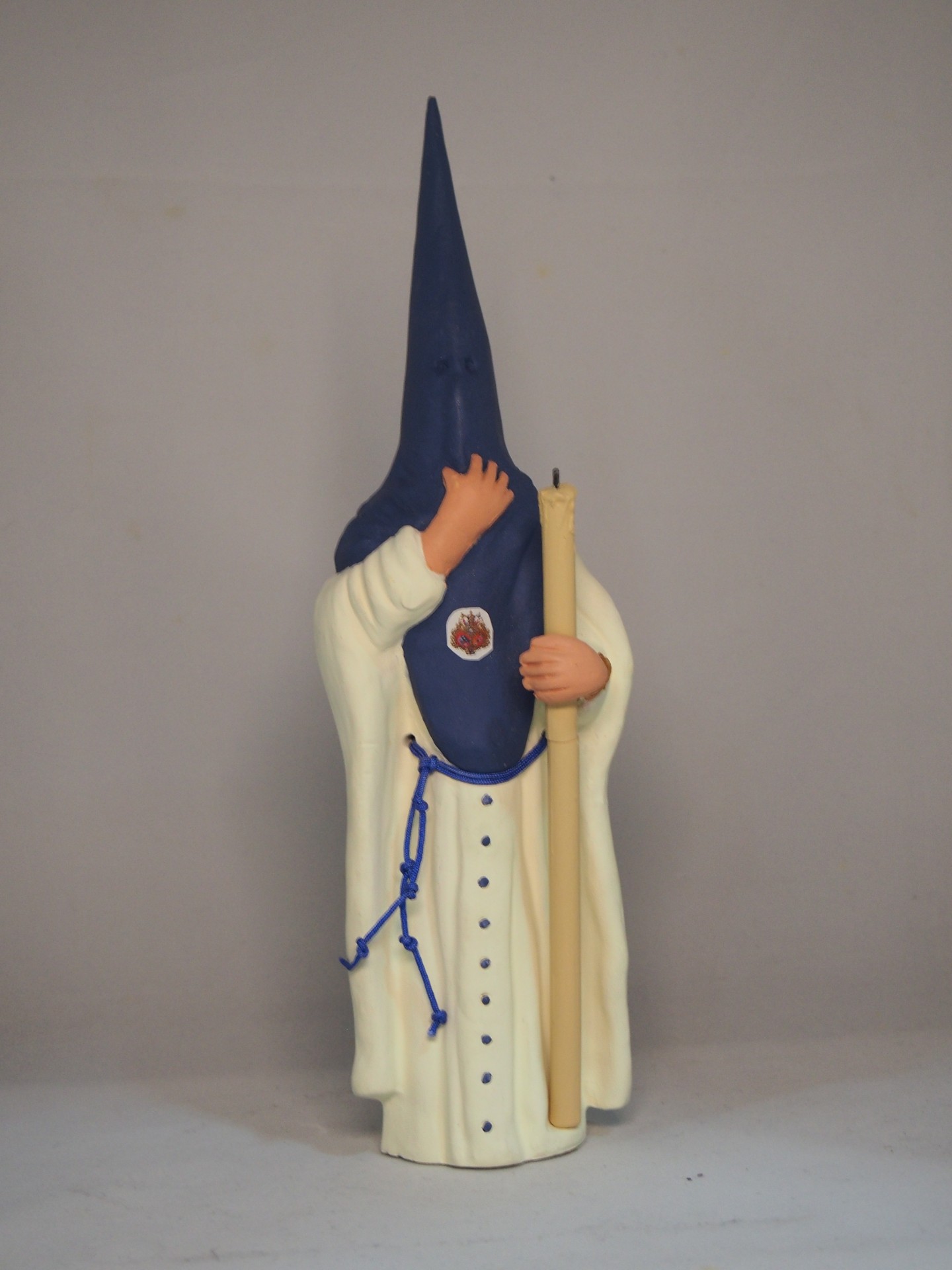 Estatueta de figura religiosa com túnica branca e capuz azul