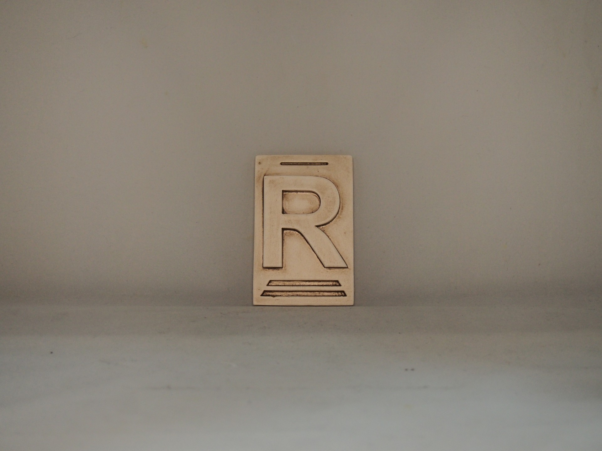 Bloco de madeira com letra R gravada