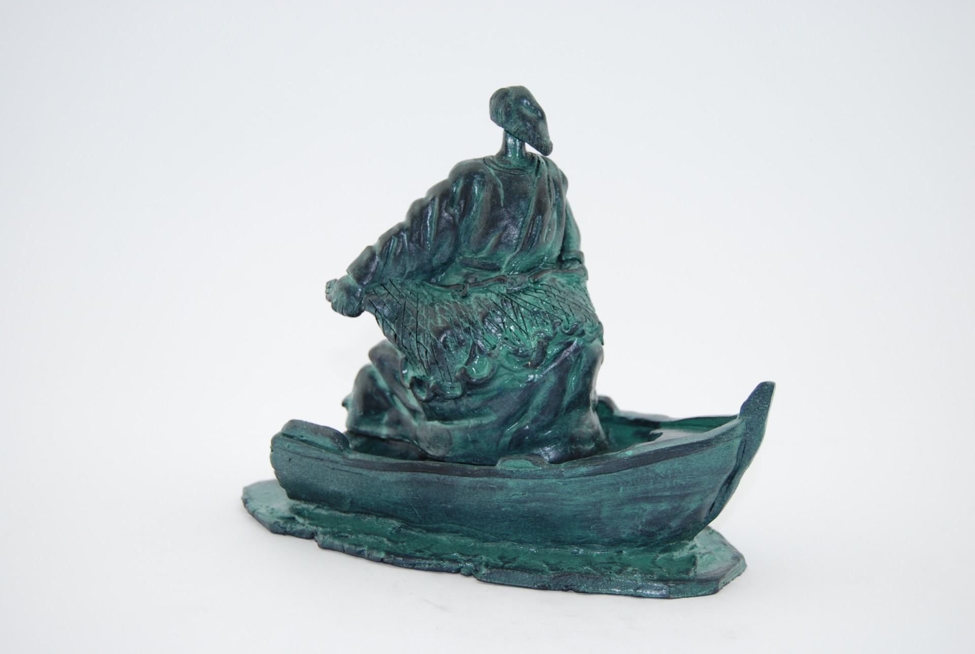 Escultura verde-azulada de barco com figura humana a remar