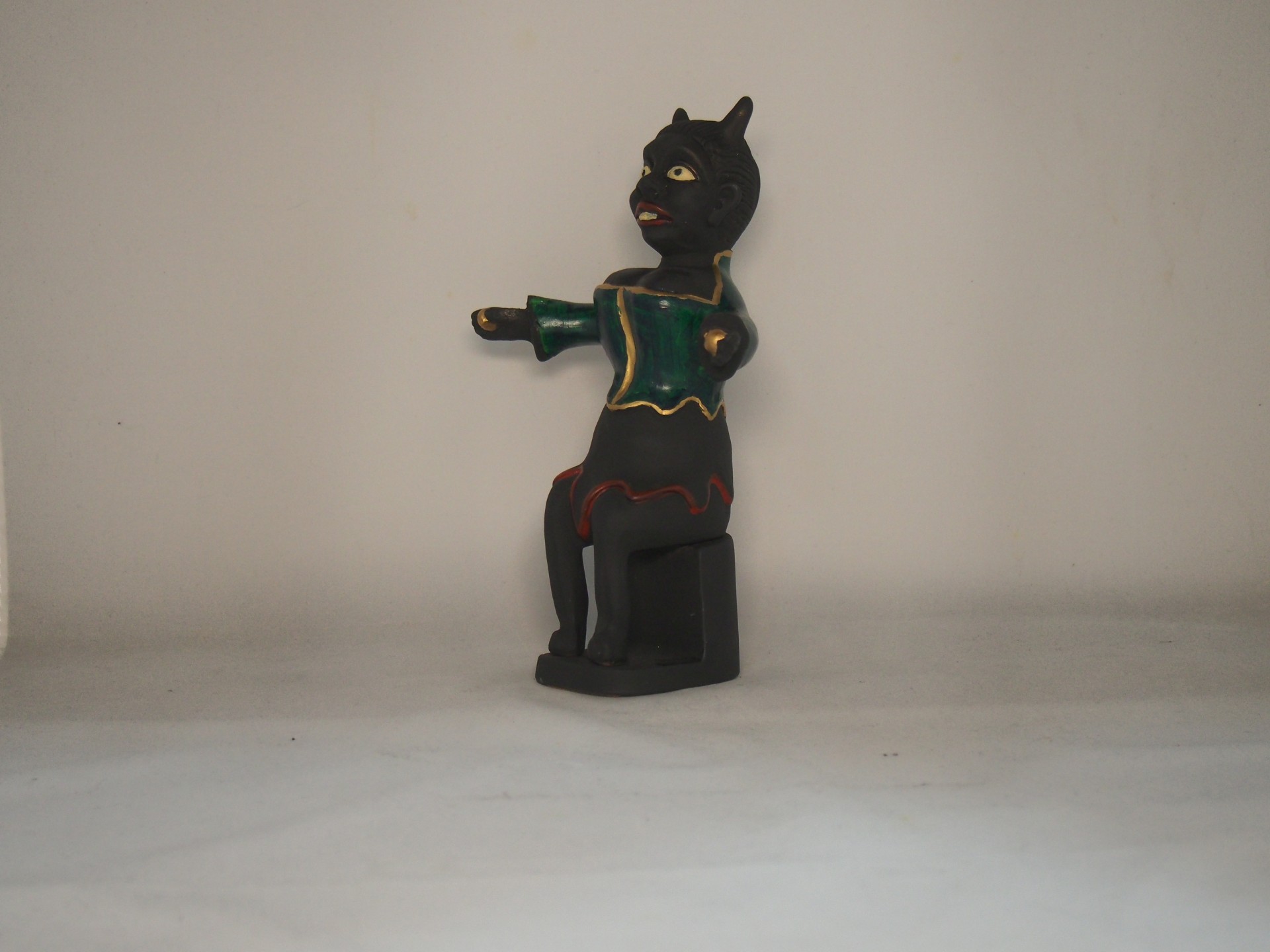 Figura de madeira pintada representando mulher mascarada sentada