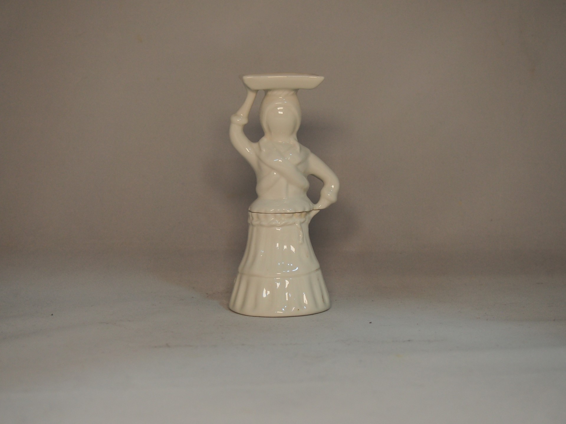 Figurina decorativa em cerâmica branca representando mulher com prato na cabeça