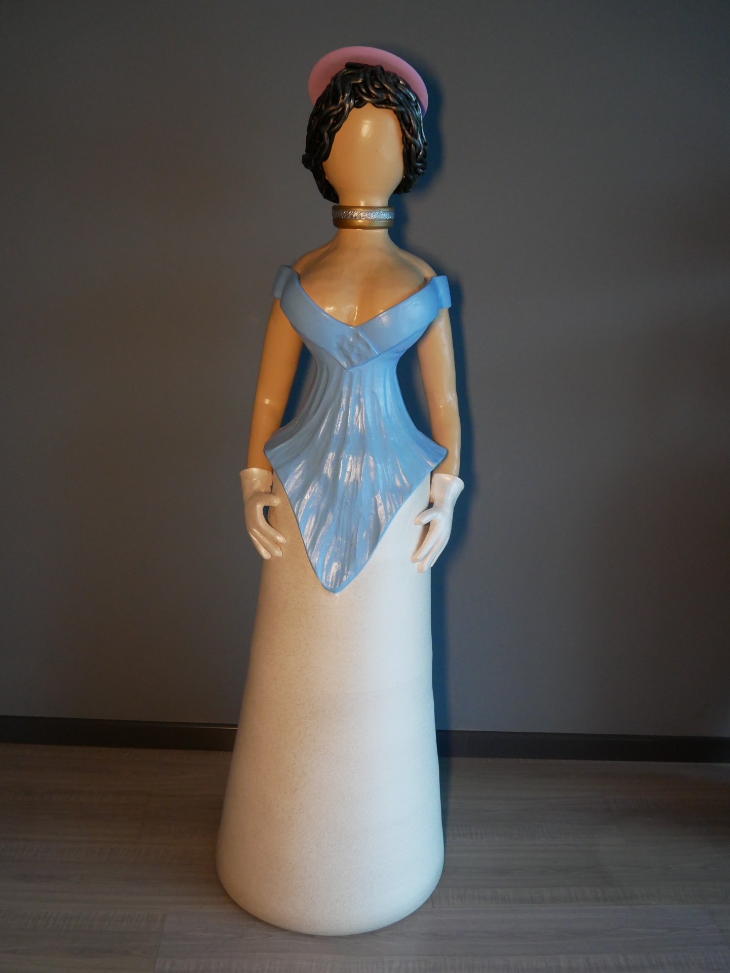 Estátua decorativa de mulher com vestido azul e branco e chapéu rosa