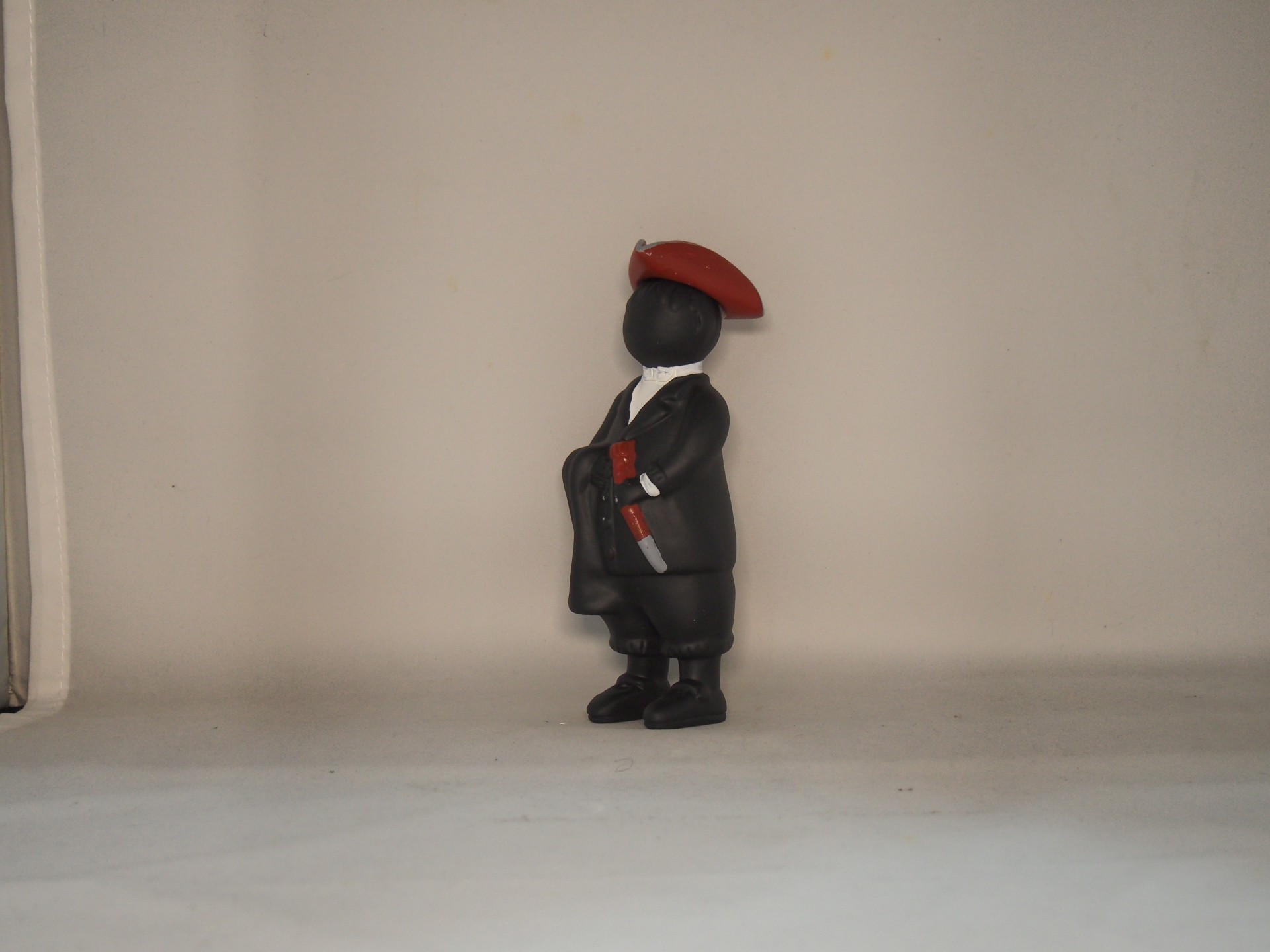 Figura decorativa vestida de preto com boina vermelha