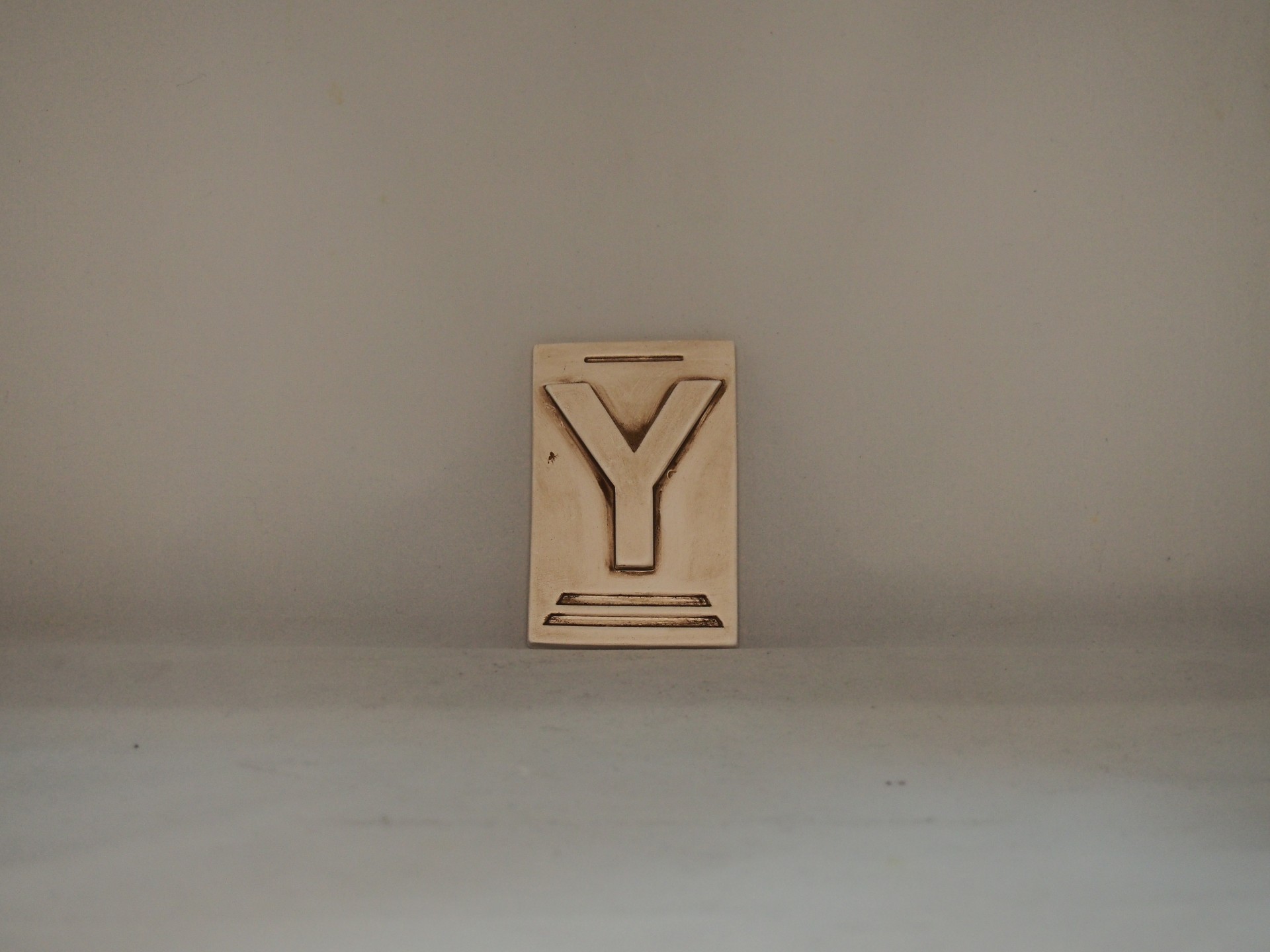 Bloco de impressão em madeira com a letra Y em relevo