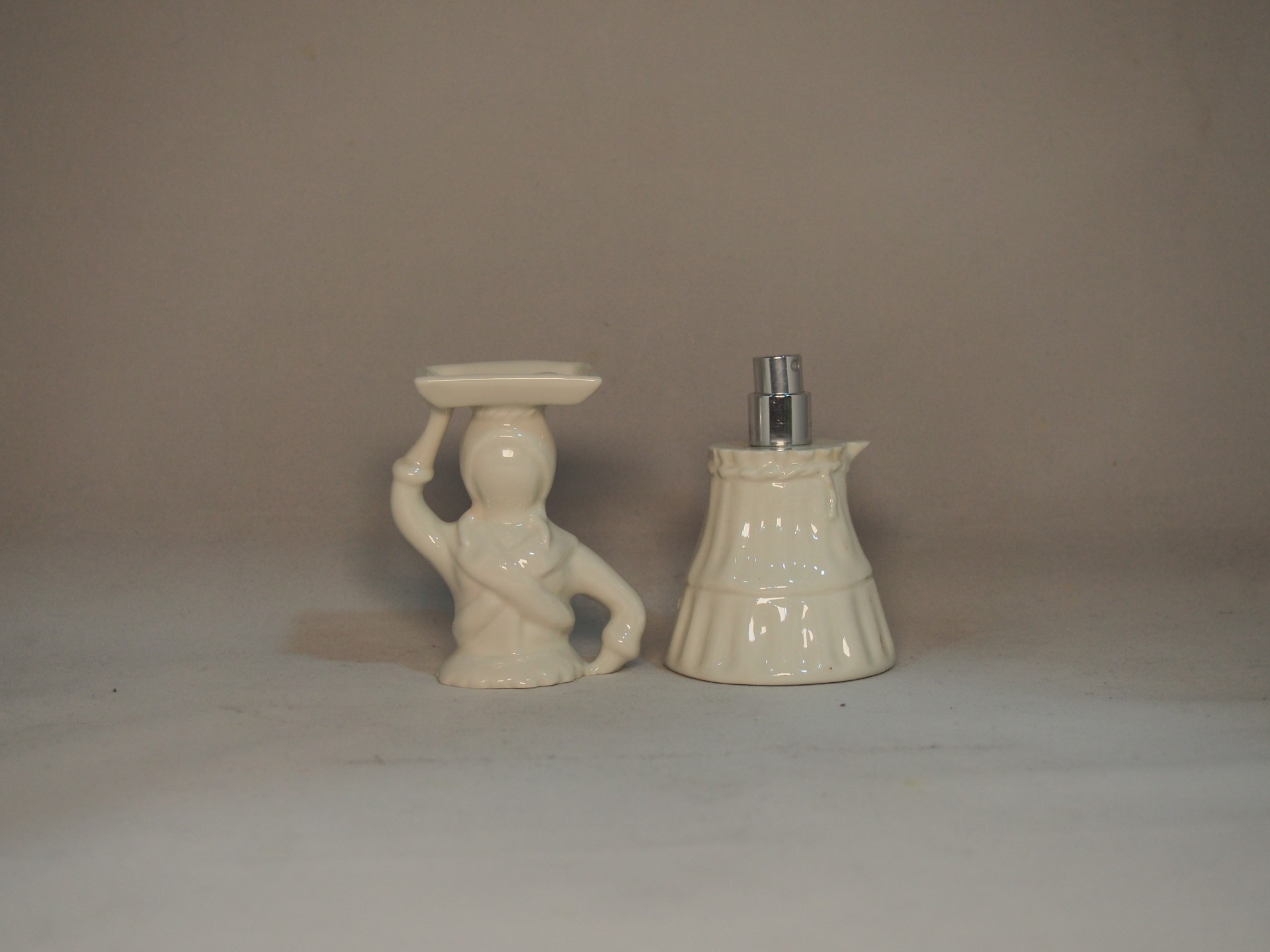 Dois objectos decorativos em cerâmica clara sobre superfície branca