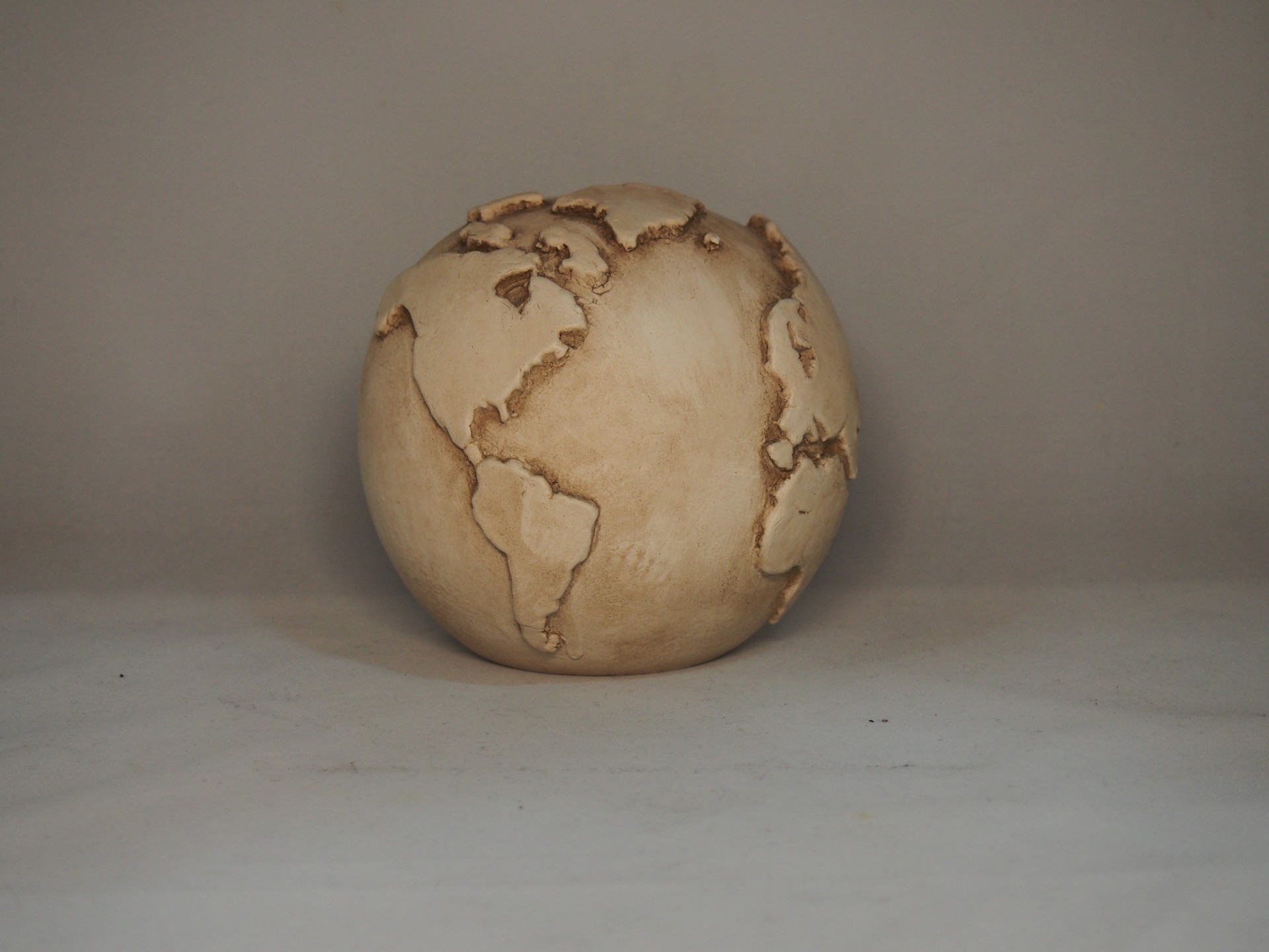 Globo terrestre decorativo em madeira clara com relevo dos continentes