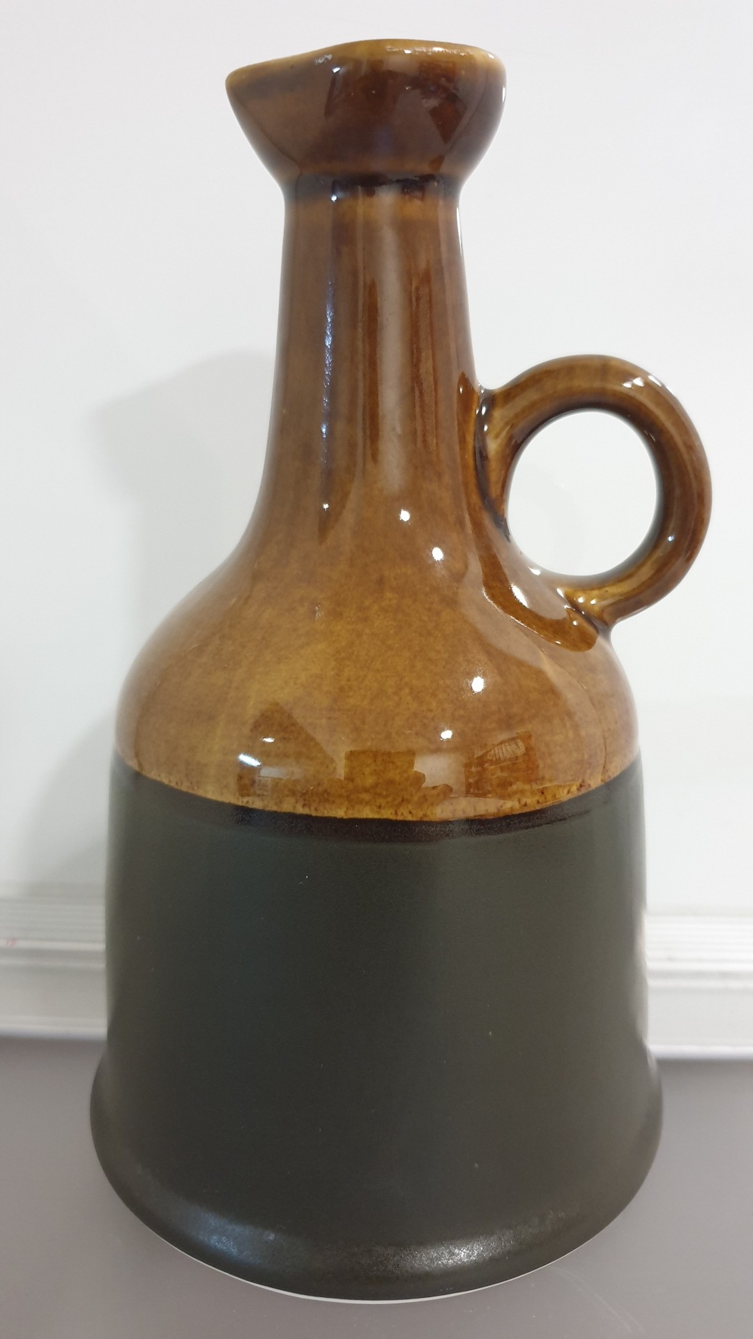 Jarro de cerâmica castanho e preto com asa circular
