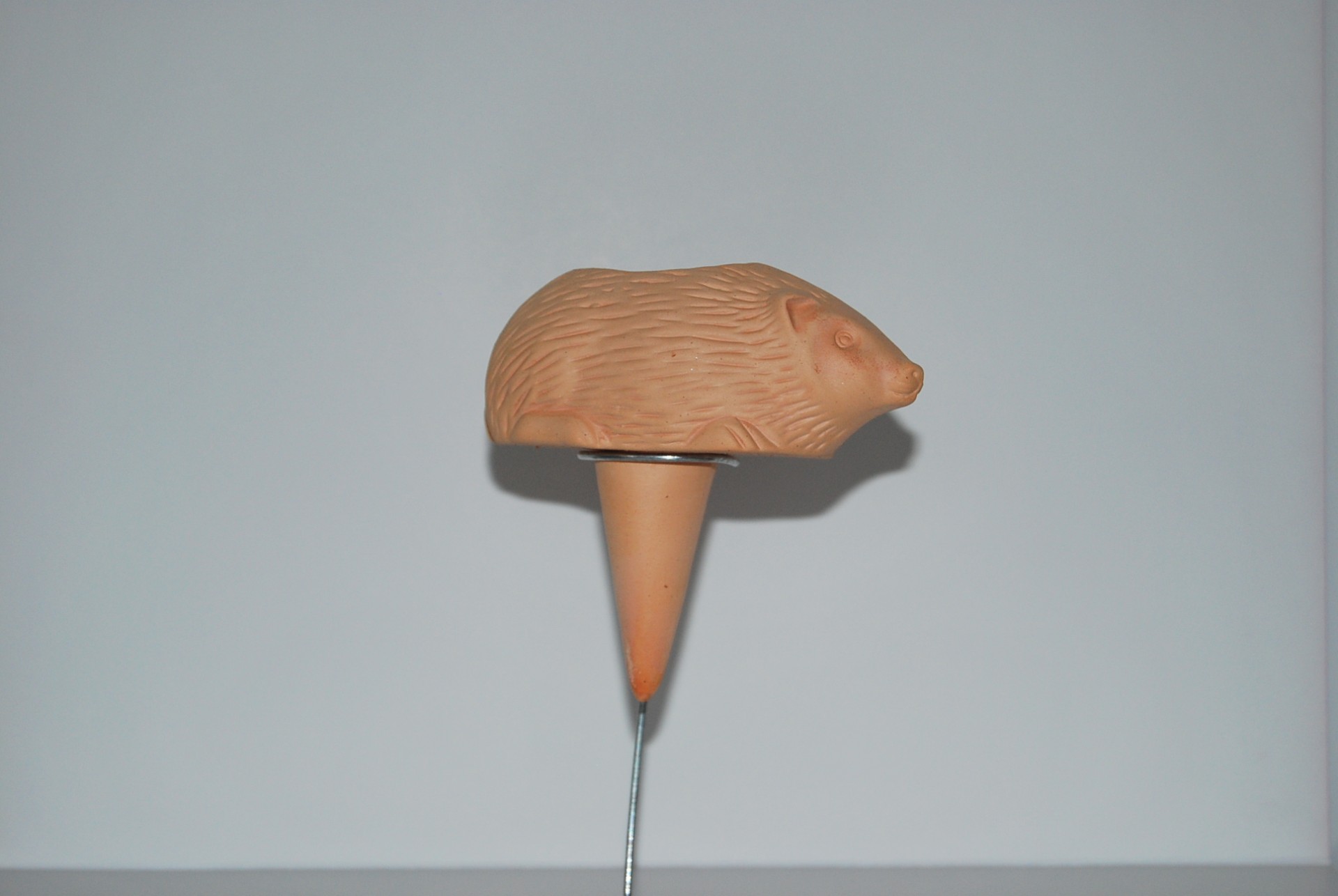 Figura decorativa em terracota em forma de porco sobre suporte cónico