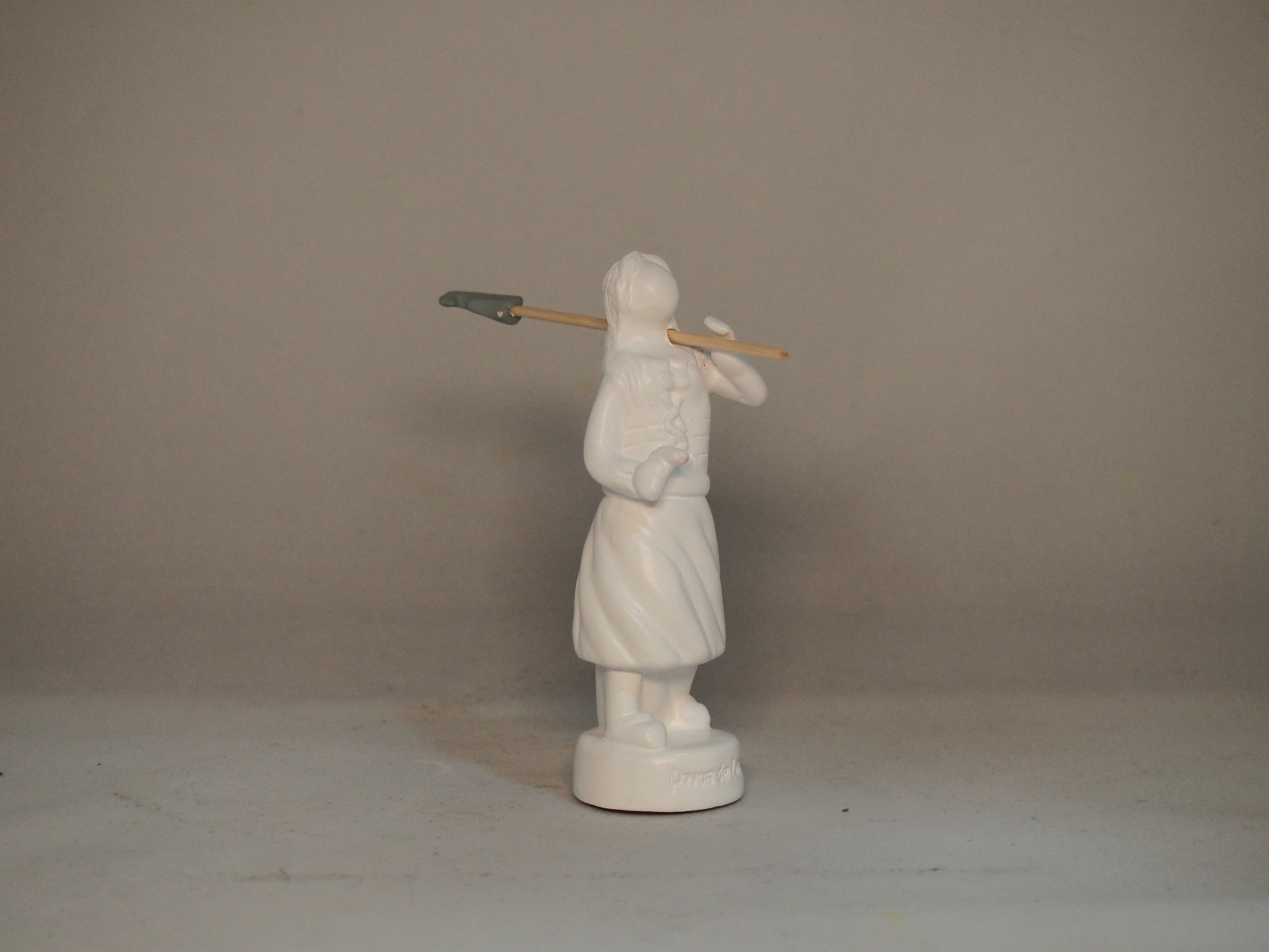Estatueta branca de figura feminina com pá pala ao ombro