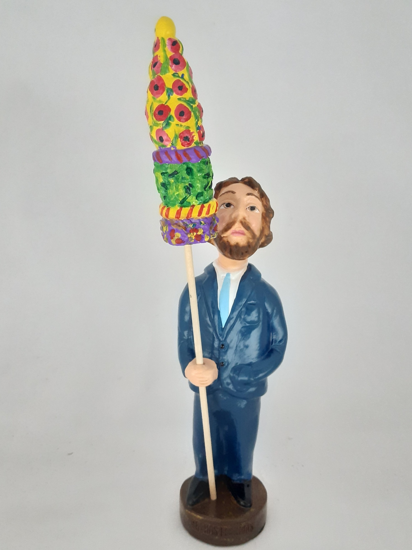 Estátua de homem segurando vara colorida com padrões vibrantes