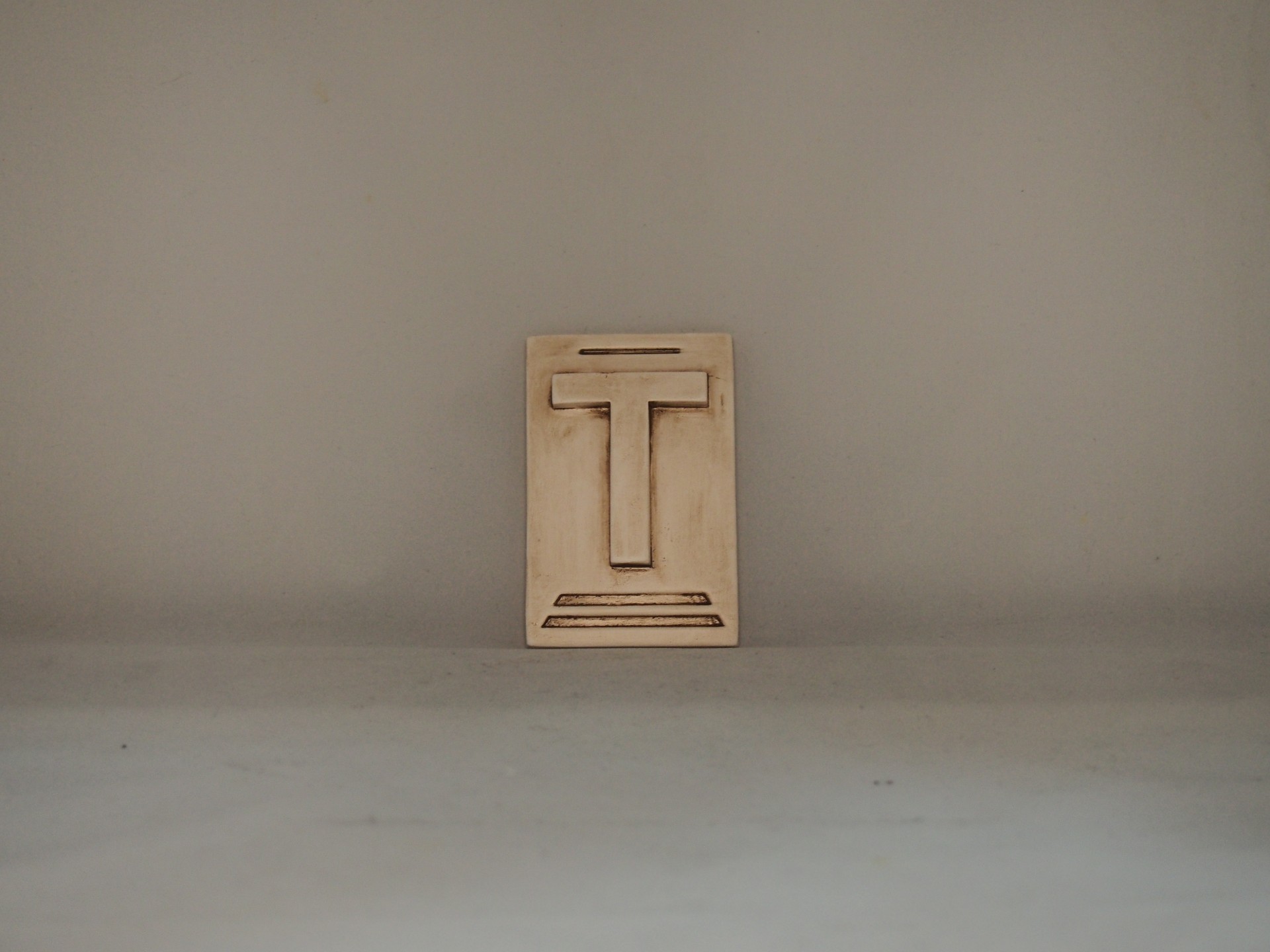 Placa de madeira com a letra T em relevo