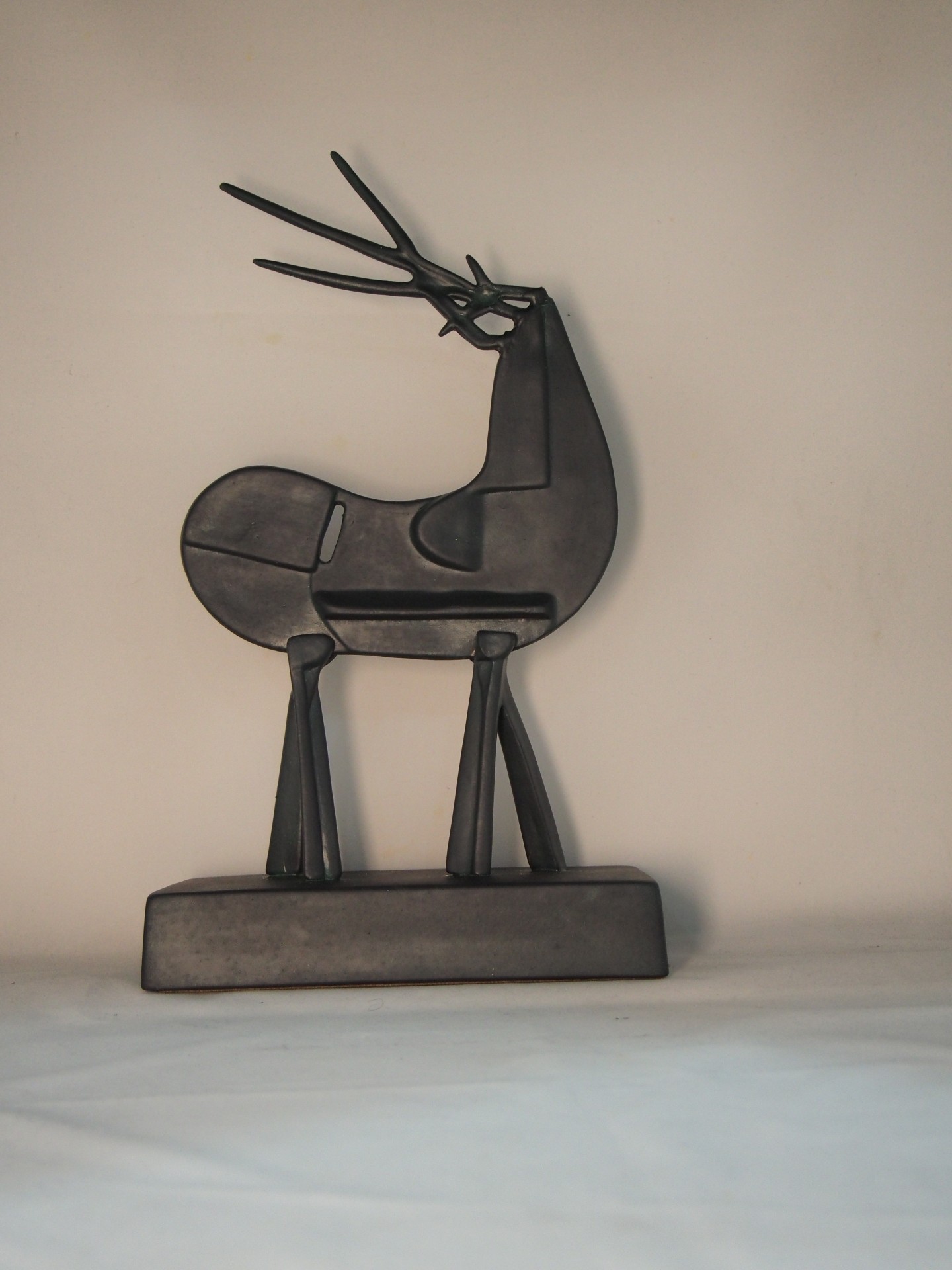 Escultura preta de rena geométrica sobre base retangular