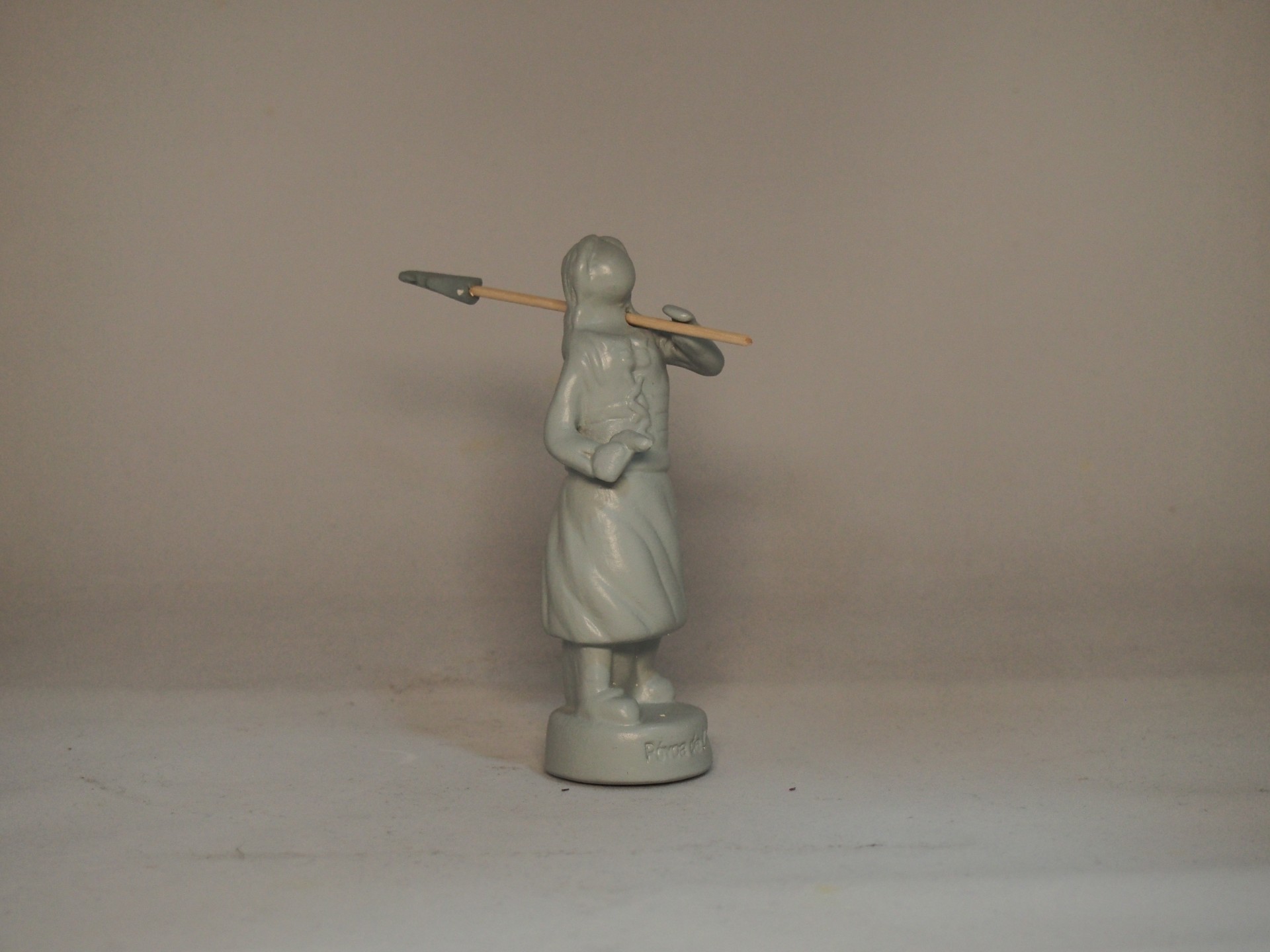 Figura cerâmica branca de mulher segurando uma lança