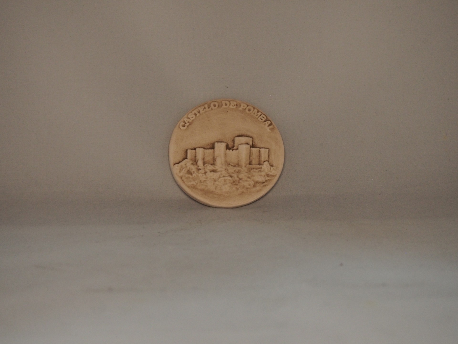 Moeda bronze com relevo do castelo e texto 'CASTELO DE PORTOMARIM'
