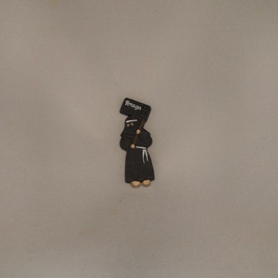 Pequeno boneco decorativo preto com placa 'BRAGA' numa superfície cinza