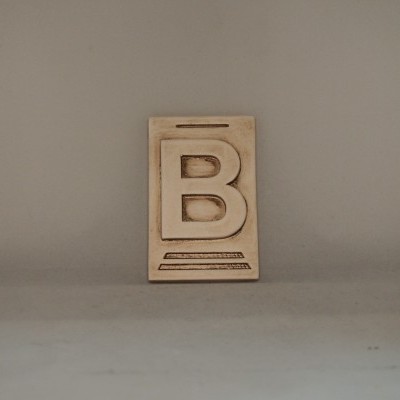 Placa decorativa de madeira com a letra B em relevo