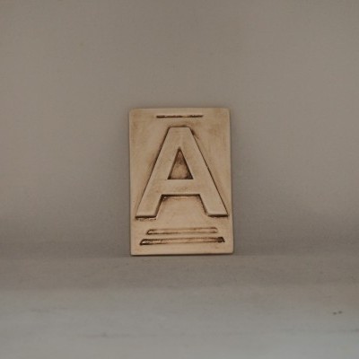 Placa decorativa com a letra A em relevo