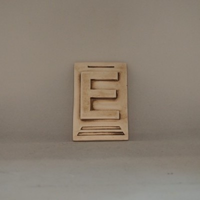 Peça decorativa em madeira clara com design geométrico recortado