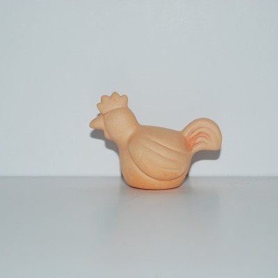 Figura em terracota forma de galinha sobre superfície branca