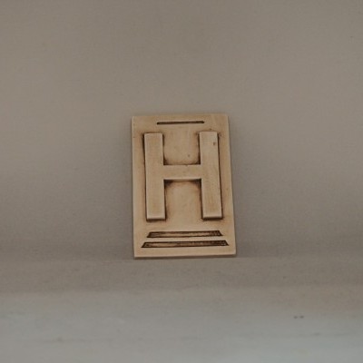 Placa de madeira com a letra H em relevo