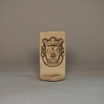 Produto de cerâmica bege com brasão gravado e texto 'MOSEGE'