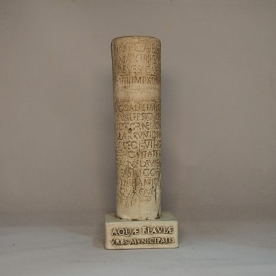 Coluna de pedra com inscrições em latim numa base retangular