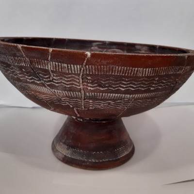 Tigela cerâmica marrom com padrões brancos e base arredondada