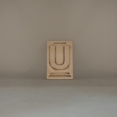 Bloco de tipografia em madeira com a letra U em relevo