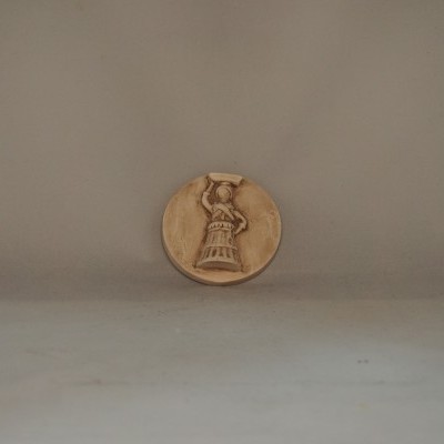 Moeda dourada com relevo de figura feminina