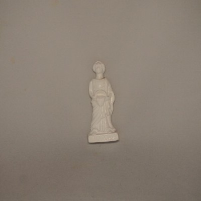 Estatueta branca de mulher com vestido e chapéu em superfície cinzenta