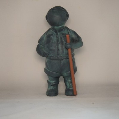 Estátua de pessoa com roupa escura e bastão castanho