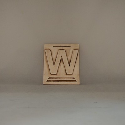 Bloco de madeira com a letra W gravada em relevo