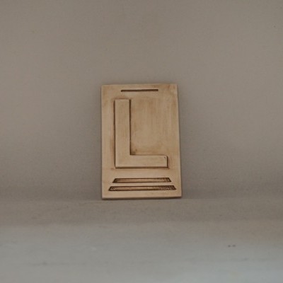 Placa decorativa de cerâmica bege com relevo geométrico em fundo cinza