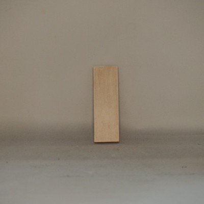 Tabela retangular de madeira clara contra parede cinzenta