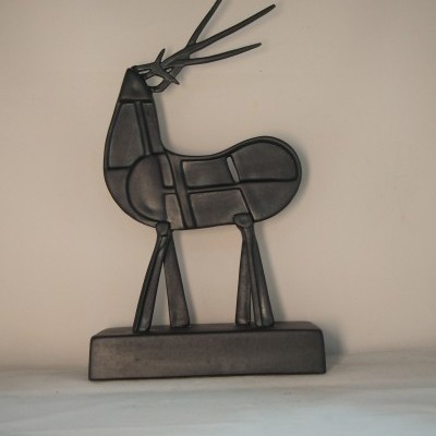 Escultura de metal preta em forma de veado estilizado