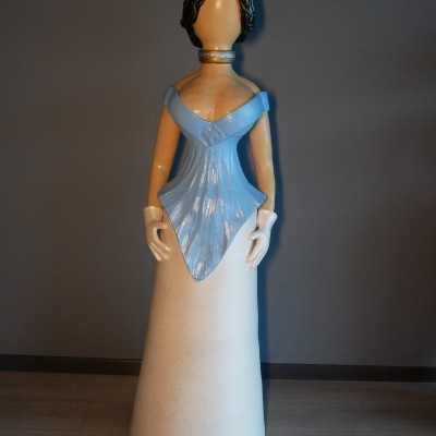 Estátua decorativa de mulher com vestido azul e branco e chapéu rosa