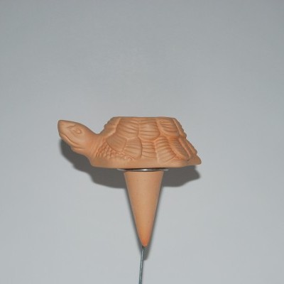 Objeto decorativo de terracota em forma de tartaruga sobre suporte metálico