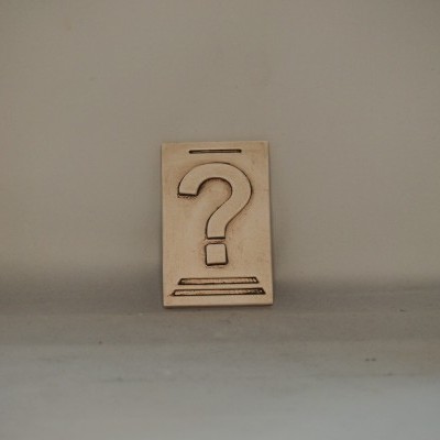 Placa de madeira com ponto de interrogação recortado