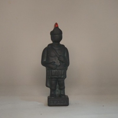 Figurina preta de soldado com chapéu vermelho em base com texto B.P.A.G.A.