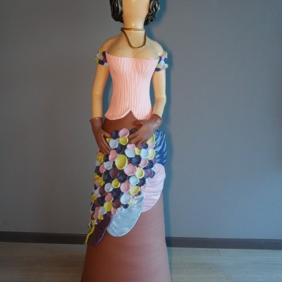 Estátua decorativa de mulher com vestido colorido e cabelo encaracolado
