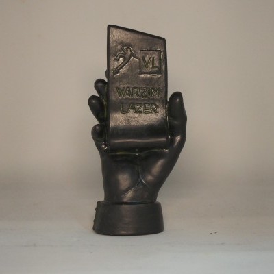 Escultura de mão preta segurando um cartão com texto em relevo