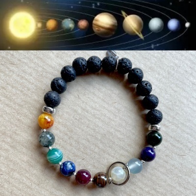 Pulseira elástica com contas pretas e coloridas sobre superfície neutra